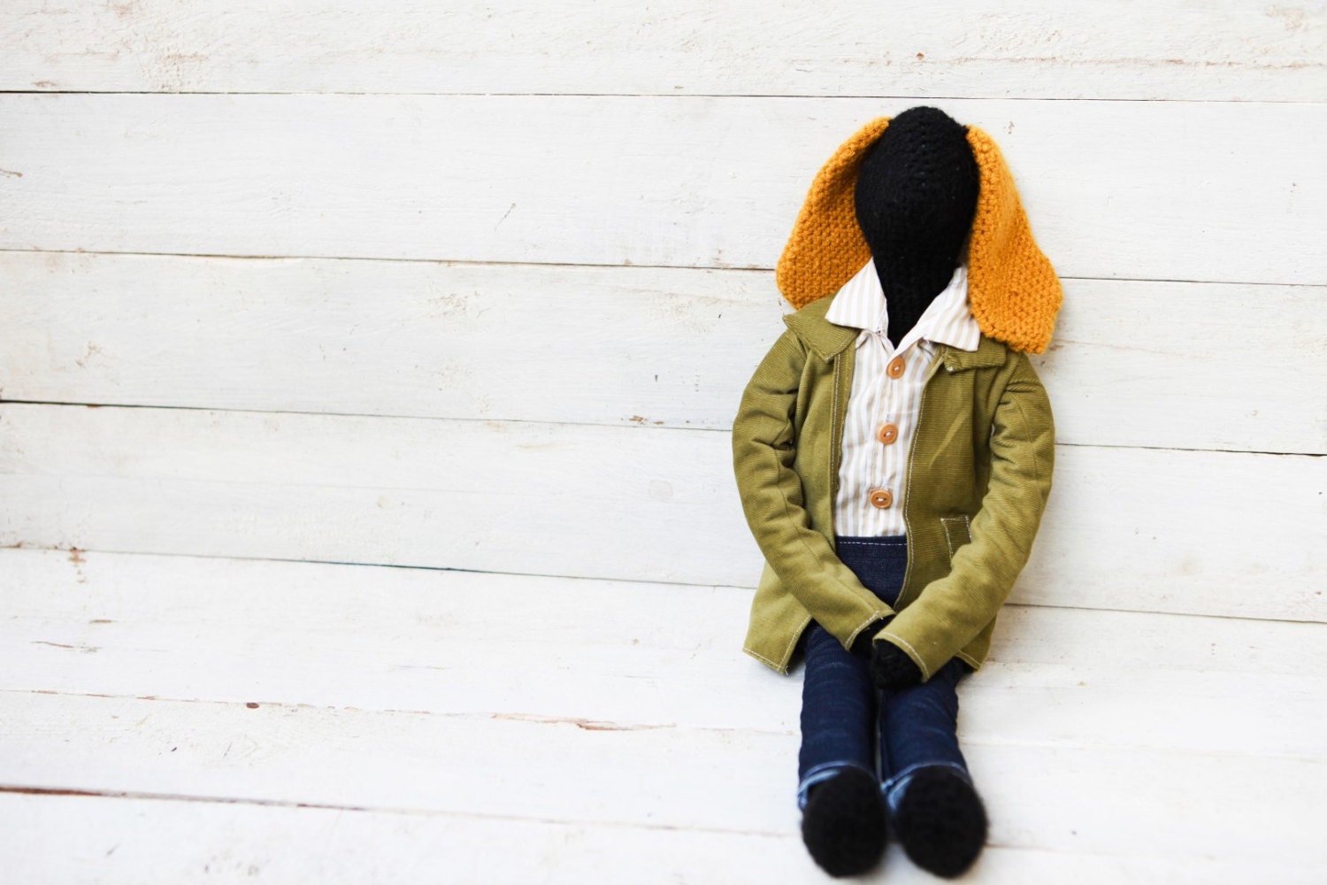 Black crochet rabbit doll.Mustard yellow ears.Vintage style doll.Wearing dark blue jeans and beige striped shirt.Green velvet jacket