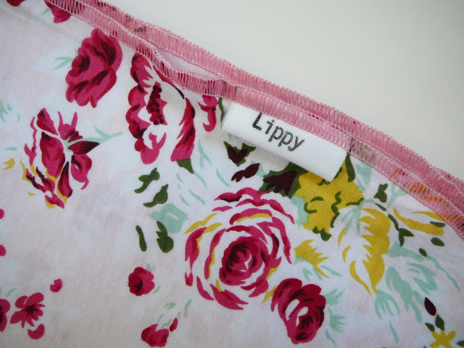 Girl baby blanket. Size 31 by 40 inches. Floral print with pink edging. Soft and stretchy knit fabric.