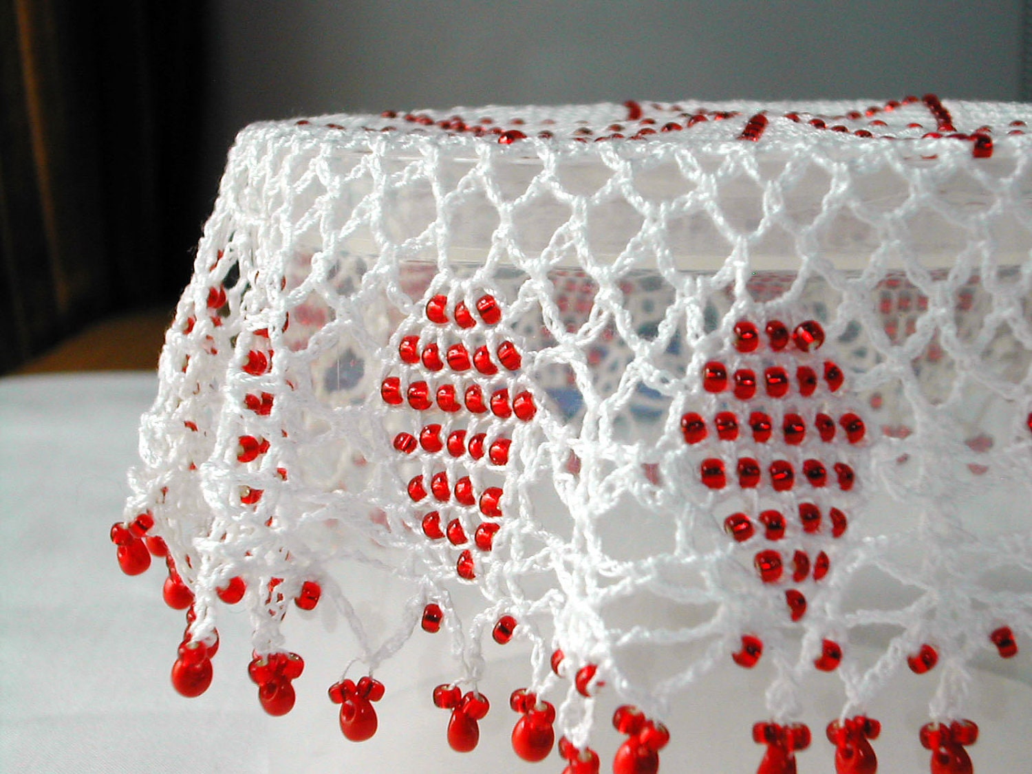 white crochet doily with raspberry red sead beads