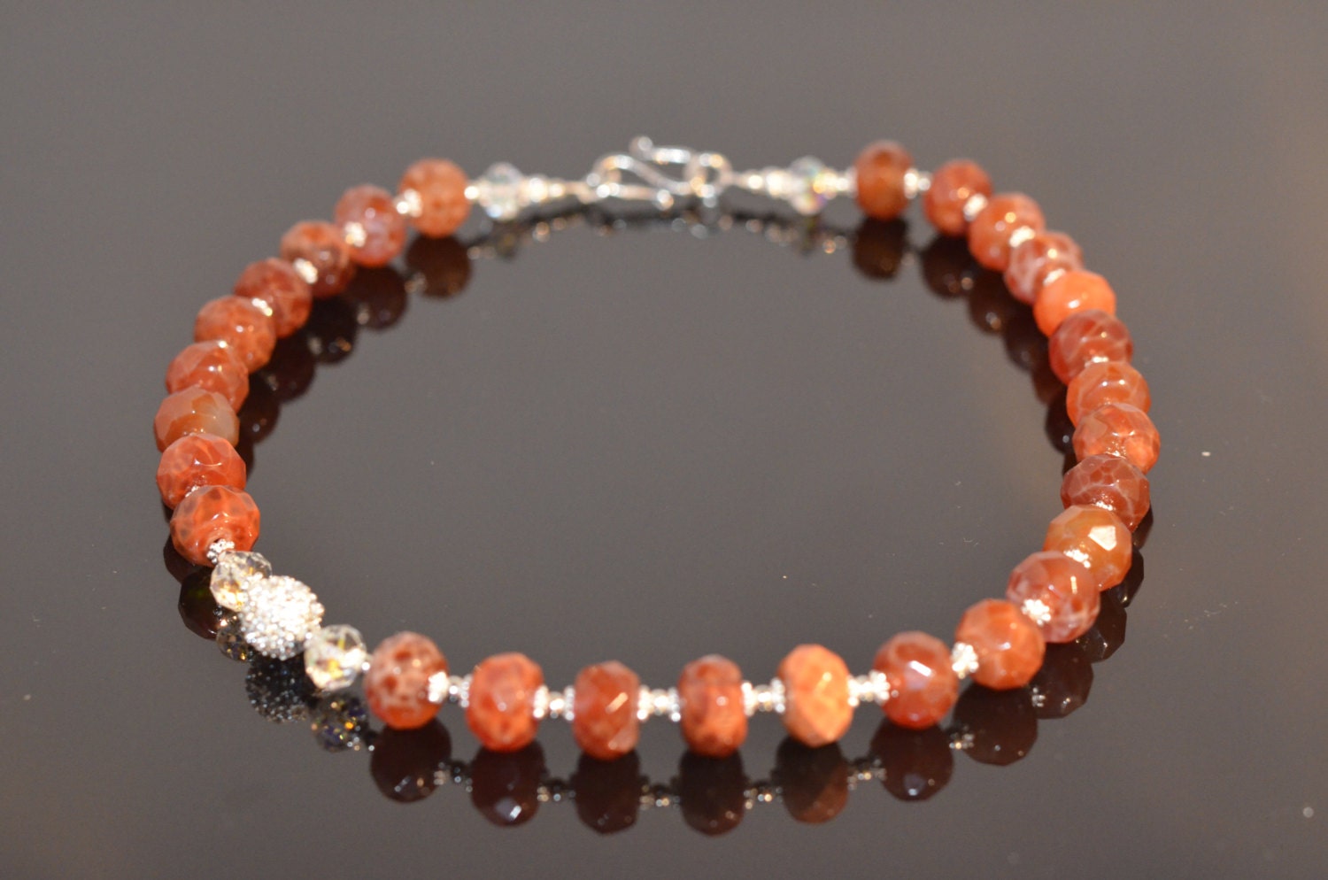 Faceted Fire Agate, Swarovski crystals, Sterling silver beads and Sterling silver hook clasp. Stunning handmade necklace.