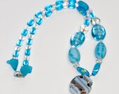 Aqua and Light: Glass necklace finished with acrylic flowers