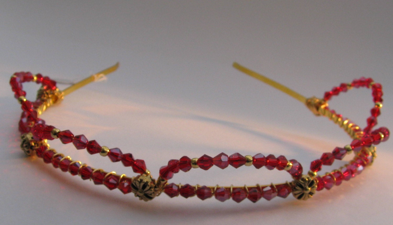 FREYA tiara  - a traditional, regal design in gold with sparkling, rich, deep red crystals forming a simple crown
