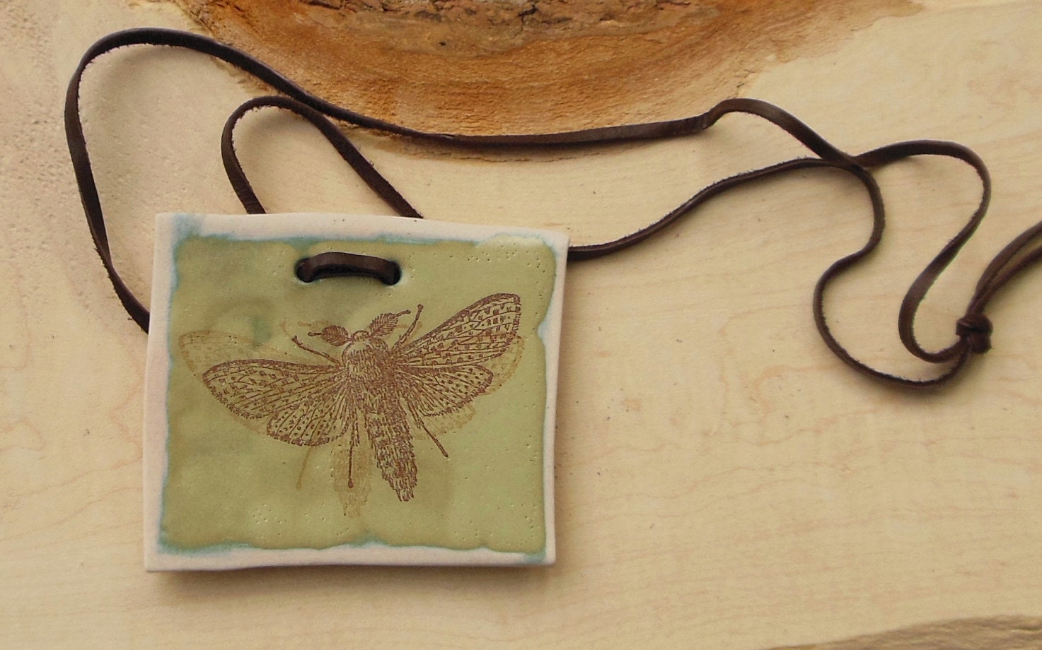 Moth in Motion, porcelain necklace on a simple leather thong