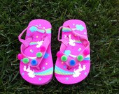Adorable toddler flip flops with fun balls that match the pattern, have soft straps on back.