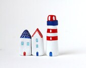 Two little clay houses and a striped lighthouse - red, white and blue