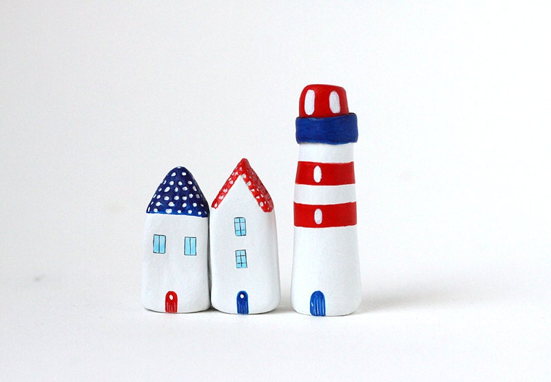 Two little clay houses and a striped lighthouse - red, white and blue