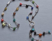 Crocheted multicolor festival necklace with bronze circle charm and fringe