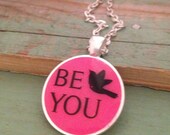 Bright fleuro pink pendant necklace with bird and 'be you' quote. Silver  finish. 1 inch