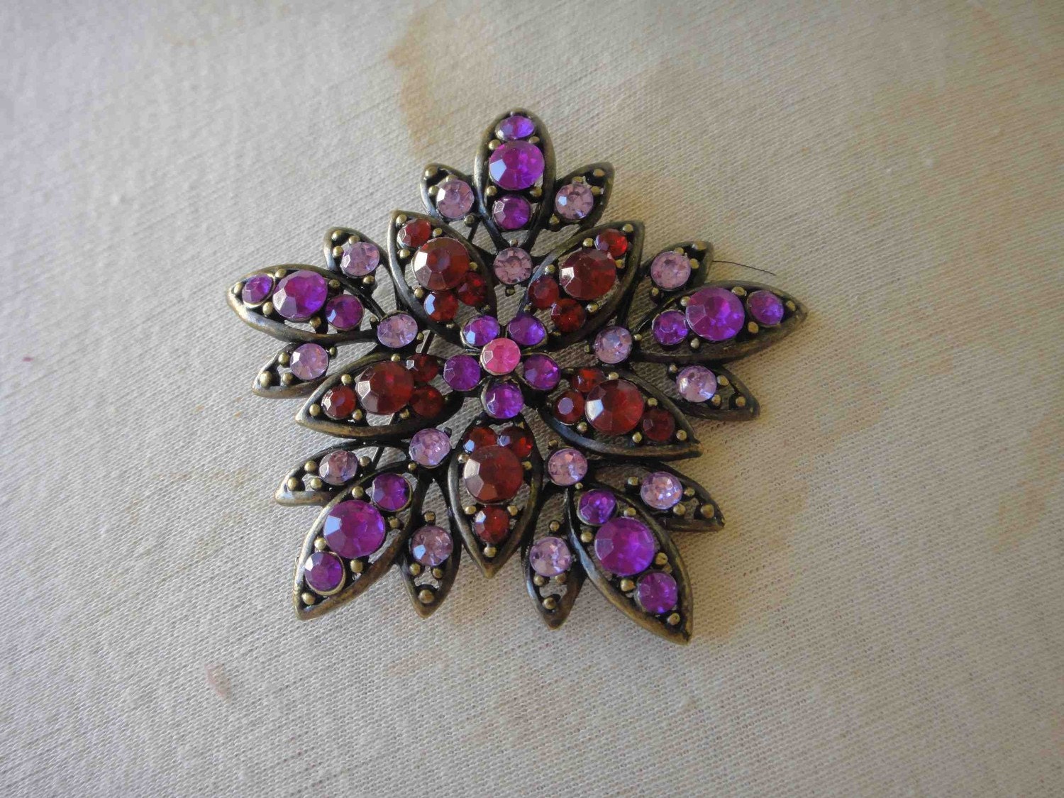 Beautiful brass color brooch with multiple colors of rhinestones 1 piece listing