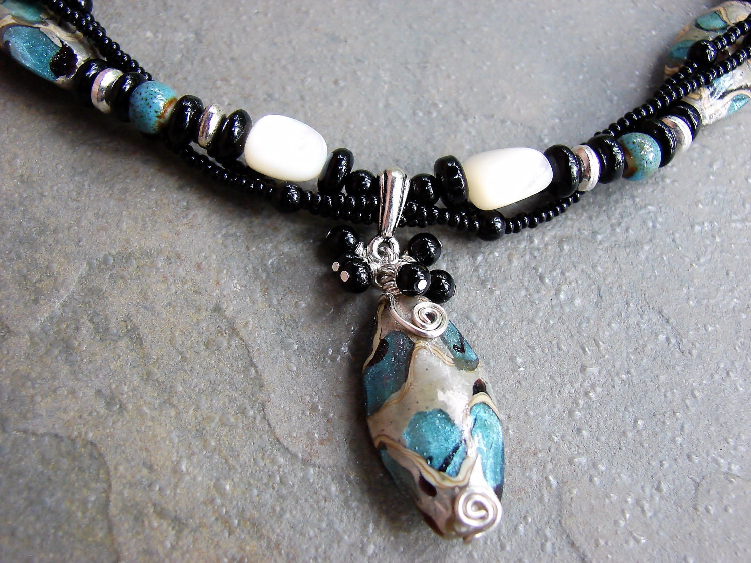 black, blue, white and silver twisted three strand glass bead necklace with hand wrapped pendant