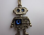 MINI ROBOT NECKLACE. A Vintage Style Robot Charm Necklace in Antique Gold Finish with Sapphire Blue Swarovski Gem.