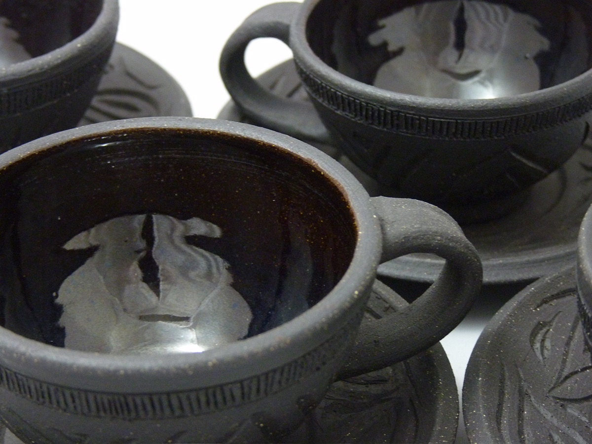 Four Carved Black Clay Tea cups and Saucers