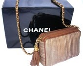Beautiful Chanel horsehair handbag or pocketbook. This one was never carried. Made of woven horsehair and brown leather with a chain strap and a generous tassel on the zipper. The black Chanel box is not original to the handbag and it's how my client has stored it all these years and it's how you'll receive it. Measures 7 x 5-1/2 inches x 2-1/2 inches. Strap is 38 inches long. There is an authentication card in four languages. Marked Made in Italy. It still has the rich leather smell. The tassel has the Chanel logo. In excellent condition.