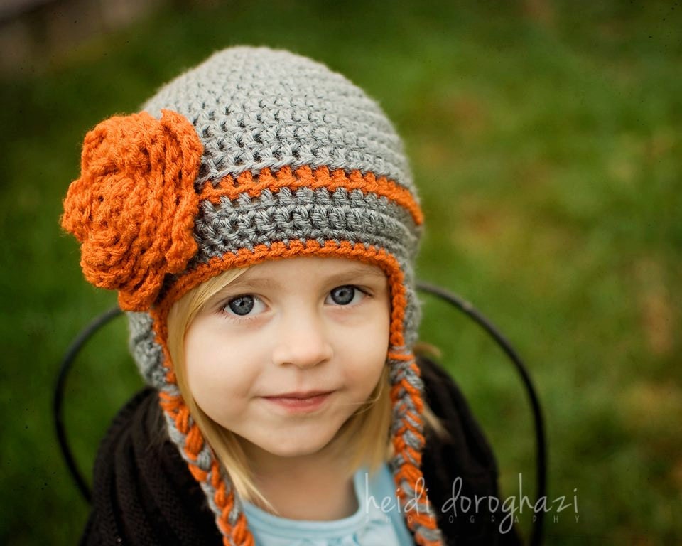 Custom made hat with over sized flower, earflaps and ties for infants, toddlers or children.