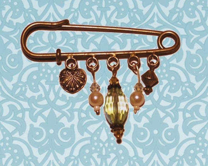 East meets west: kilt pin brooch with Swarovski crystals, faux pearls and brass-look charms