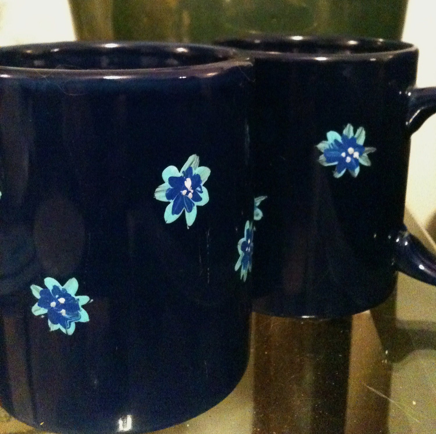Blue flowers on a pair of dark blue mugs