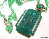 A vintage Art Deco necklace with green molded glass pendant. Pretty bird design! Beautifully decorative spacers and elongated green beads. Spring ring clasp. 19 inches in length. Pendant measures 1-1/2 x 1-1/4 inches. Some wear to the silver finish on the necklace, especially on the back of the pendant. Please see photos. Otherwise, in very good vintage condition. A beautiful statement necklace with its own unique qualities!