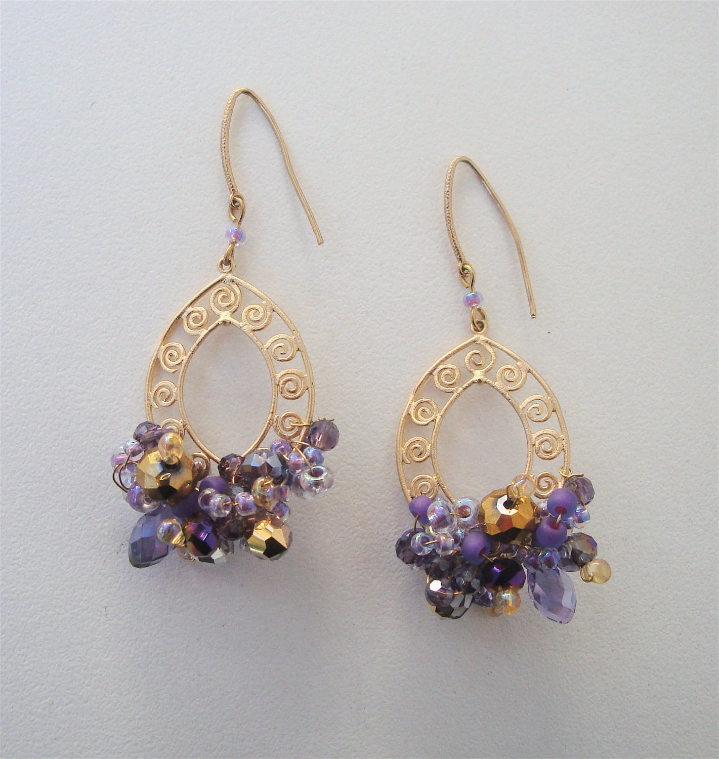Matte gold fancy hoop style chandelier earring with purple and gold swarovski crystals and seed beads all wire wrapped together with a cryst