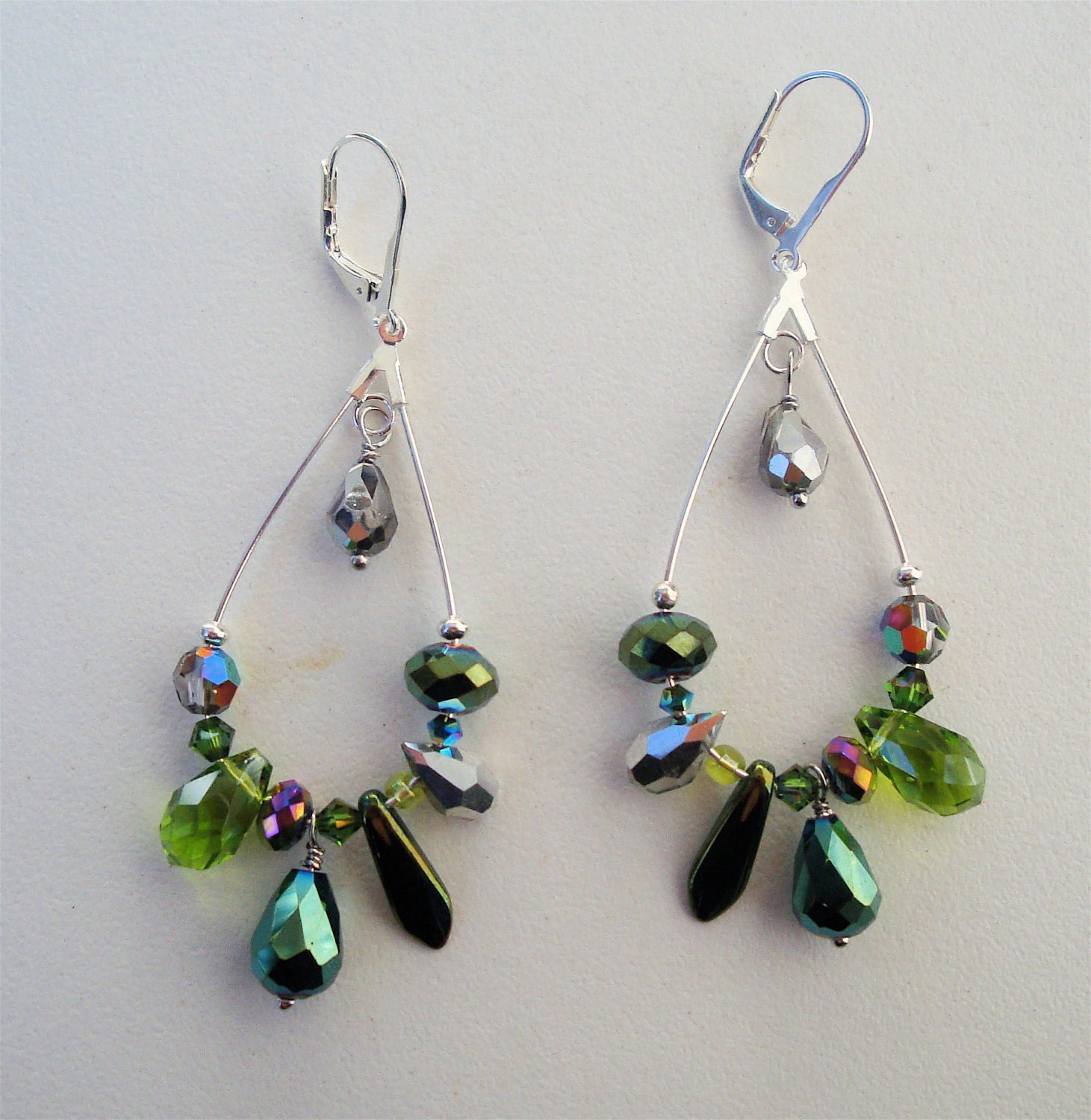 Silver elongated hoop earrings with green and silver crystals and glass beads. Very light weight and fun to wear. 2"