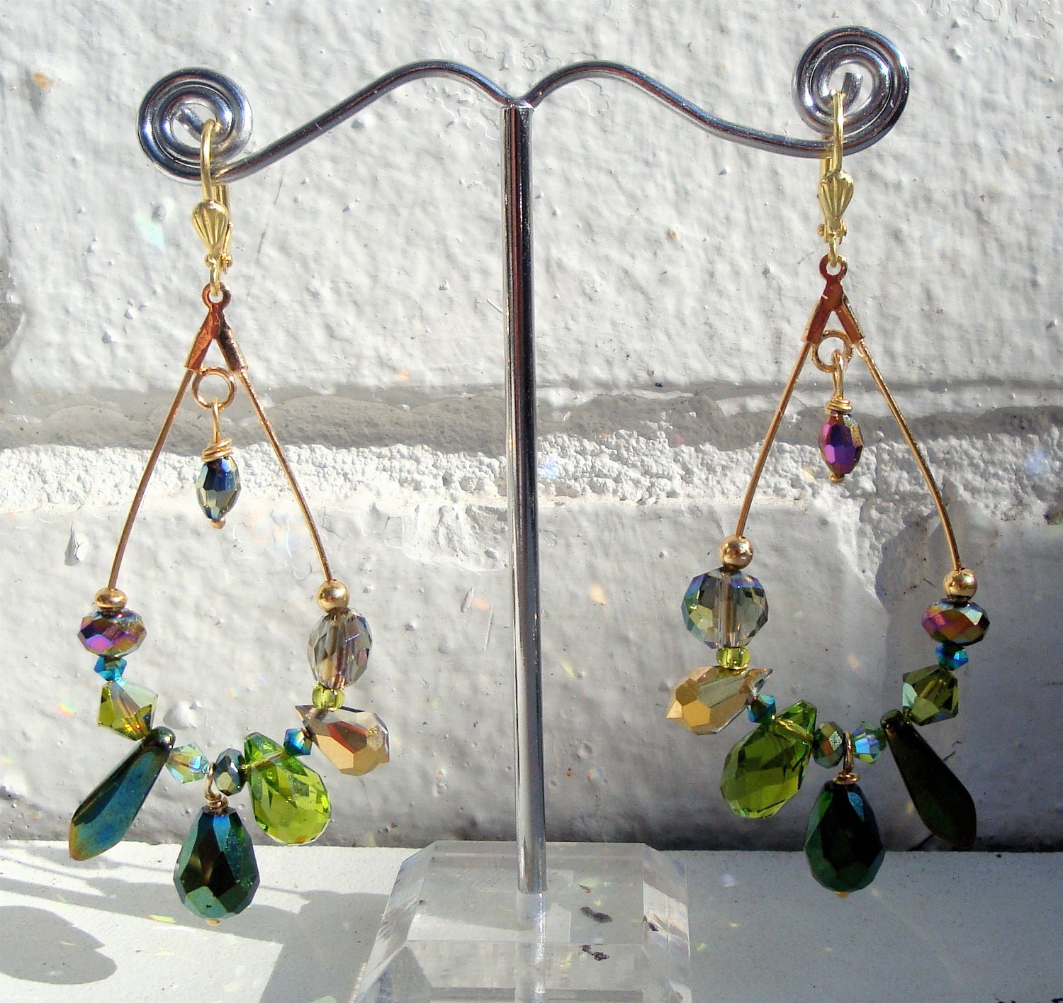Gold elongated hoop earrings with green and gold crystals and glass beads with highlights of pink. Very light weight and fun to wear. 2"