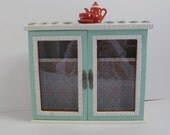 Curio cabinet with tiny teapot