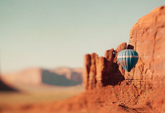 hot air balloon,Monument Valley,dreamy travel landscape photography,film colors photo, blurry tilt-shift,desert,surreal print