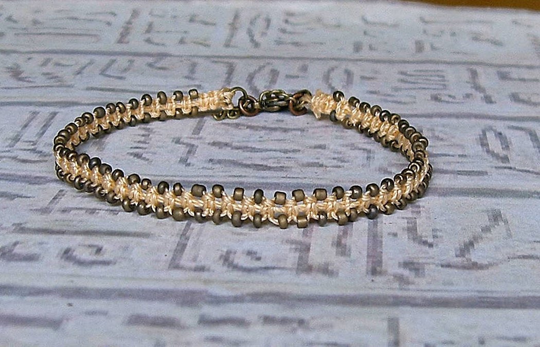 Macrame friendship bracelet in peach and bronze.