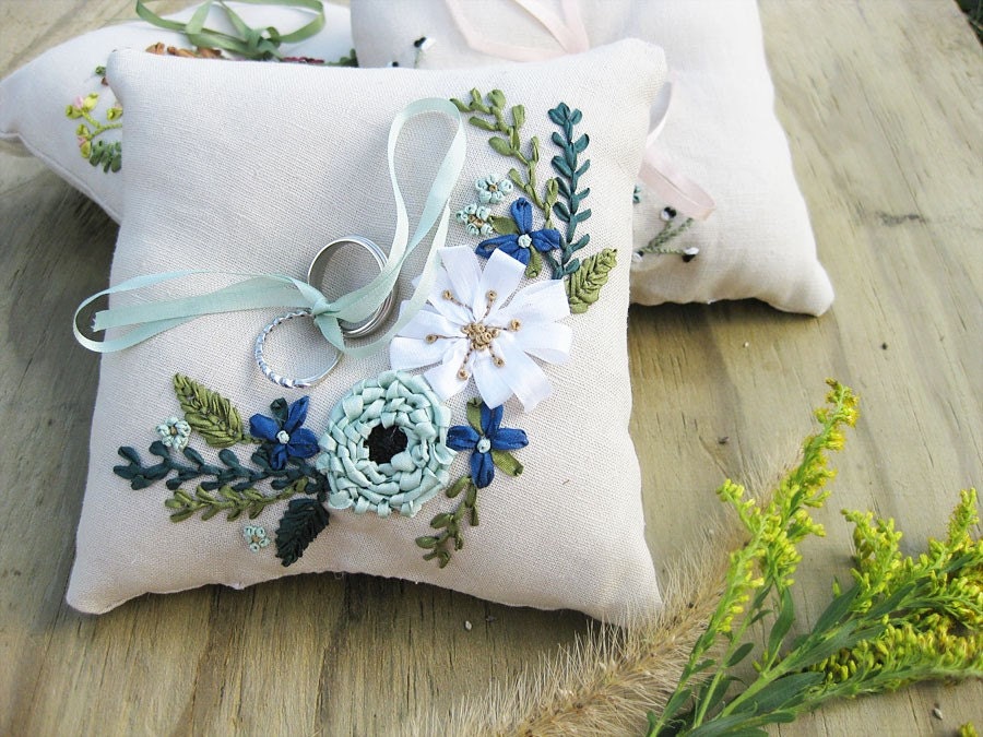 Ring pillow with ribbon embroidered flowers in deep blue, aqua, and white.
