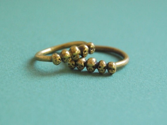 Golden row of tiny skulls ring