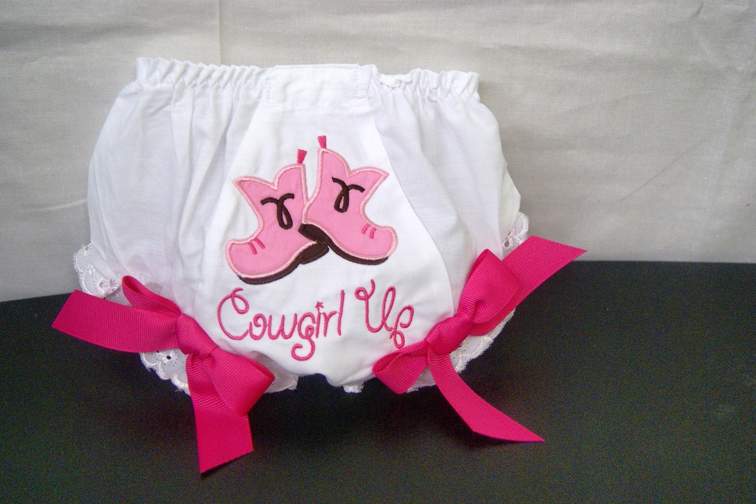 White bloomers are embellished with applique cowgirl boots and has saying