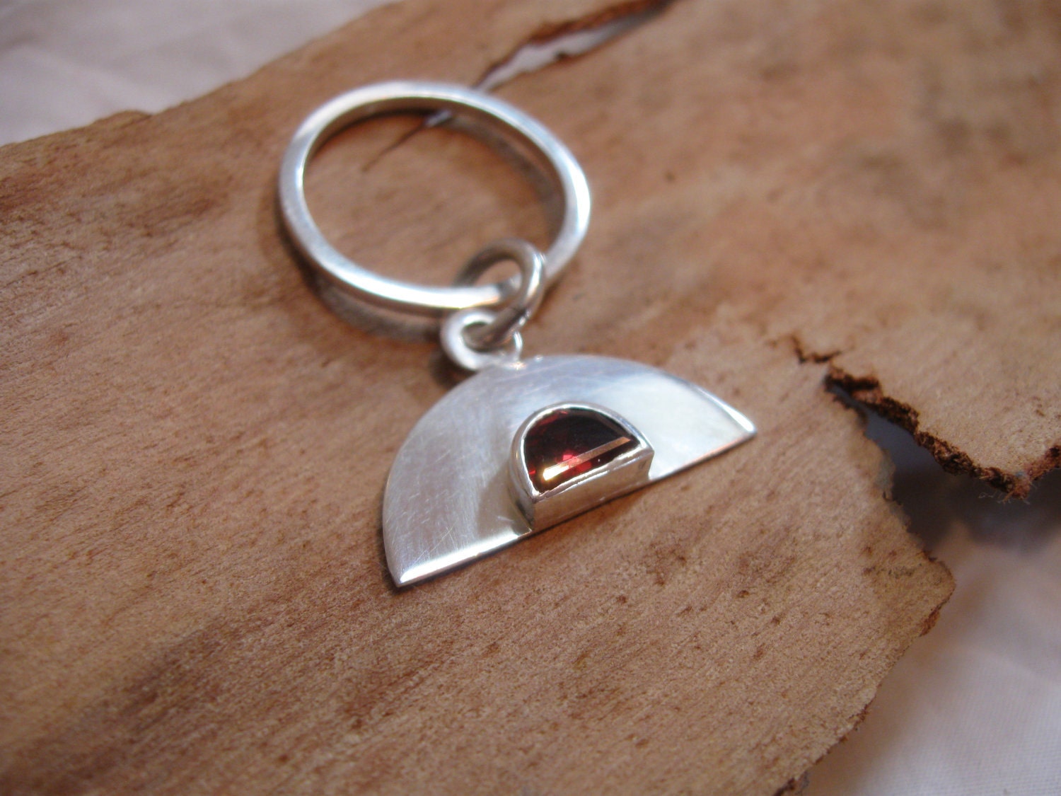 Sterling silver charm ring with bezel set, faceted D shaped garnet