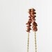 long beaded necklace. brown goldstone. geometric jewelry. triangle arrow. pebble gemstones. gold plated chain