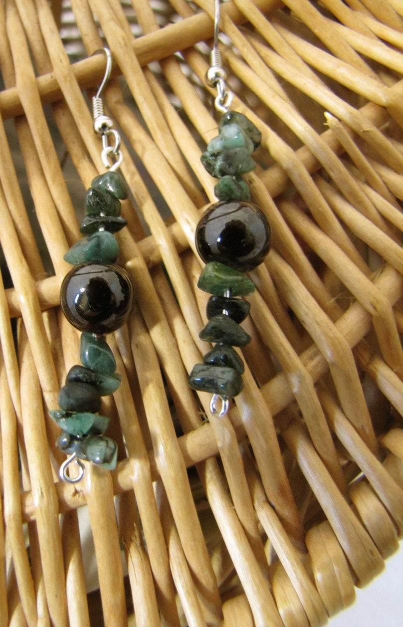 dark emerald/evergreen-colored chips of emerald, on both top and bottom of 7mm round garnet beads of a dark blood-red color