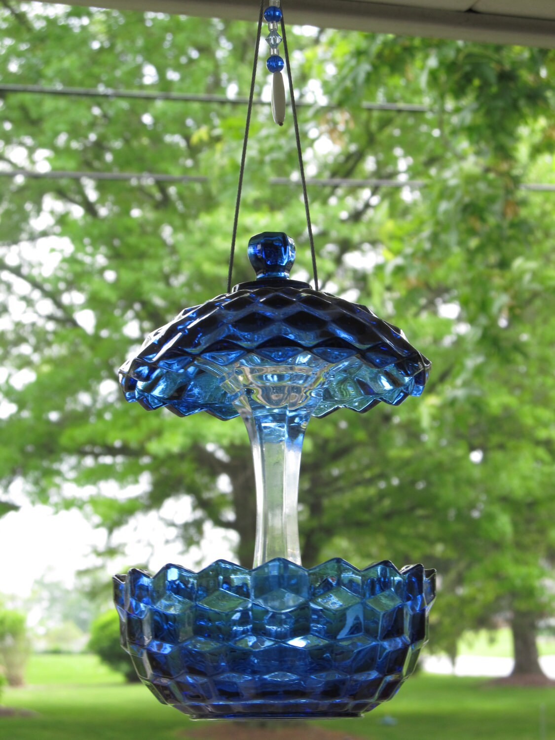 cobalt blue glass sugar bowl with lid and a glass candle stick