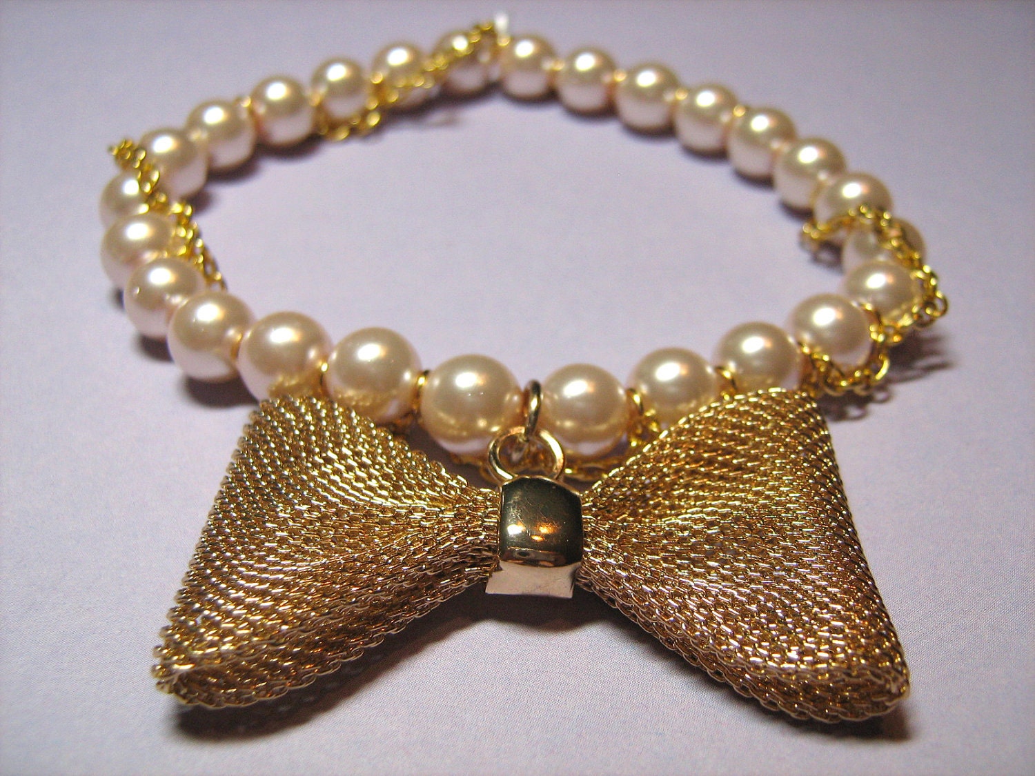 Stretch Bracelet: Pink Glass Pearls Wrapped with a Goldtone Metal Chain and Featuring a Goldtone Mesh Bow Metal Charm, for Women Stretch Bracelet: Pink Glass Pearls Wrapped with a Goldtone Metal Chain and Featuring a Goldtone Mesh Bow Metal Charm, for Women
