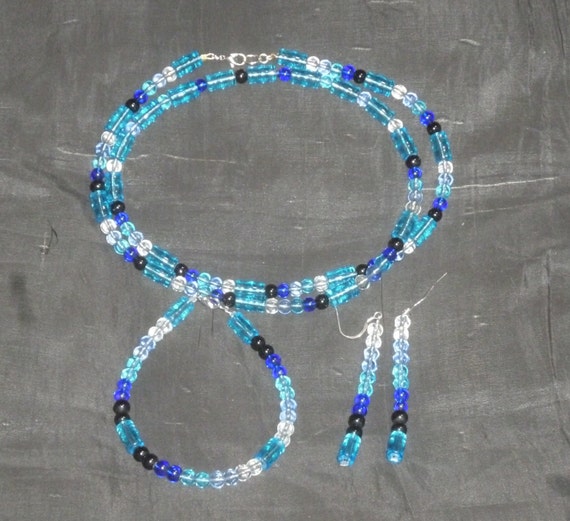 Intricate glass necklace set in white, black, and three shades of blue.