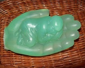 Baby Bhudda soap resting in a realistic hand
